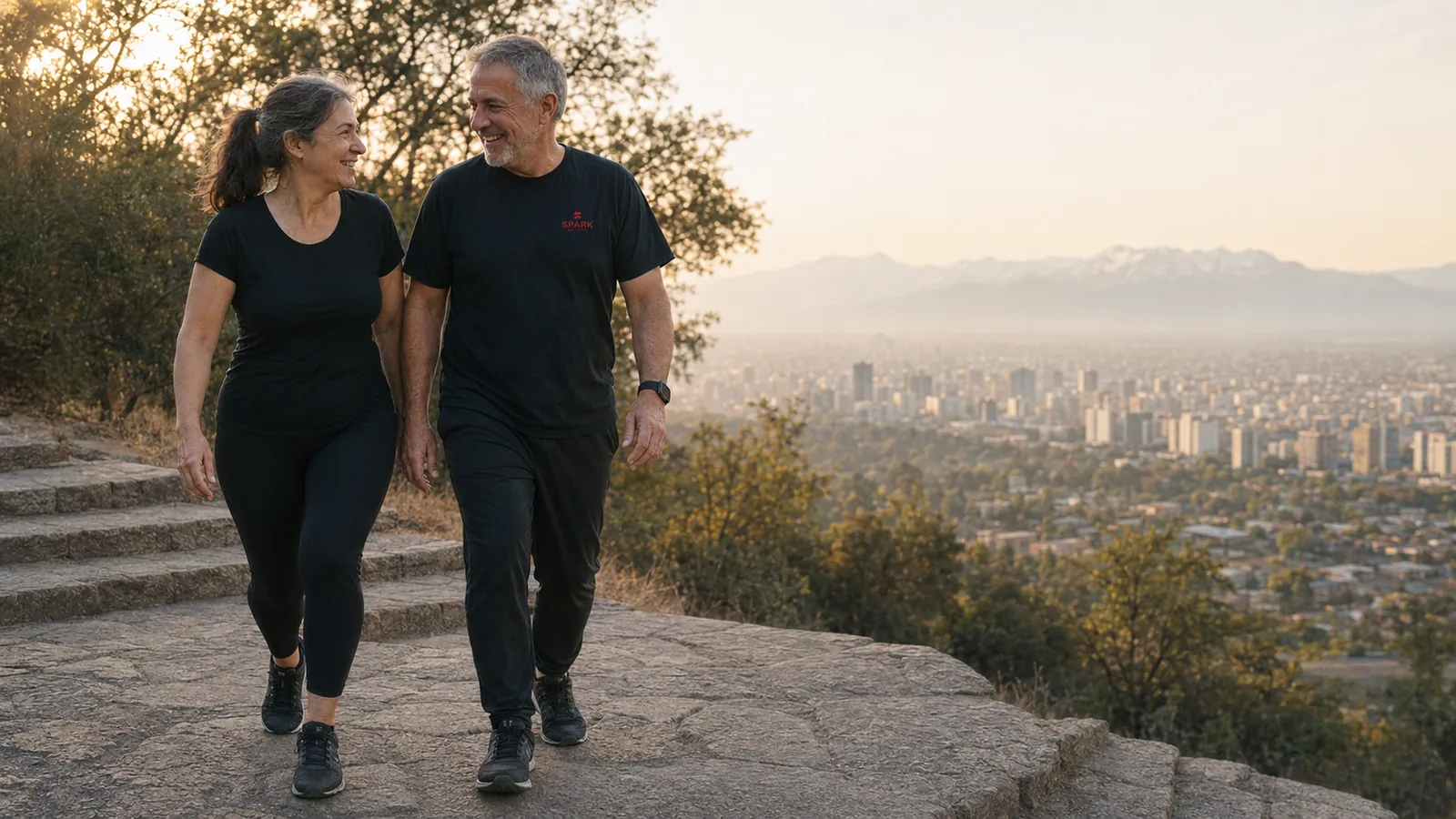 Una pareja camina al atardecer en un sendero sobre Santiago